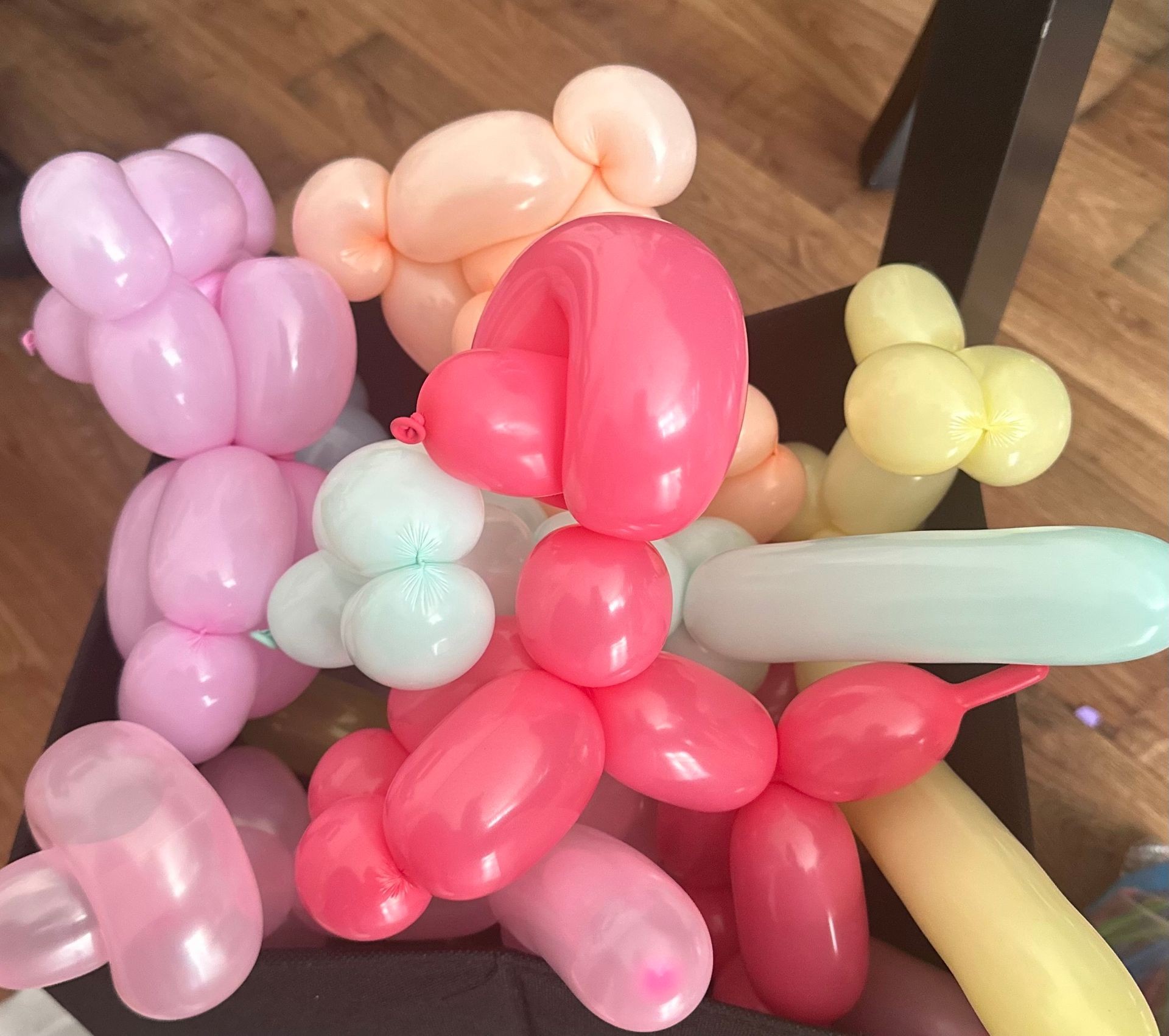 A bunch of colorful balloon animals on a wooden floor.